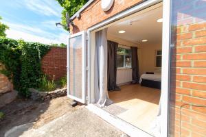 an open door of a brick house with a bedroom at Brookvale Guest House Room 8 in Southampton