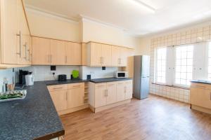 a large kitchen with wooden cabinets and a refrigerator at Brookvale Guest House Room 8 in Southampton +18 photos