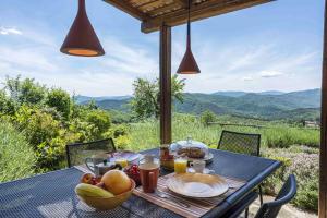 a table with a bowl of fruit on it with a view at Villa Ciciliano by MMega in Monte Santa Maria Tiberina +37 photos