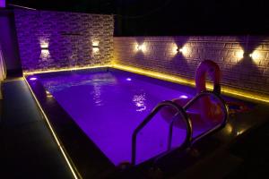 a swimming pool with purple lighting in a room at The Bungalow Seven in Lonavala
