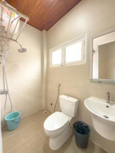 a bathroom with a white toilet and a sink at Home Thỏ Vân Anh in Da Lat