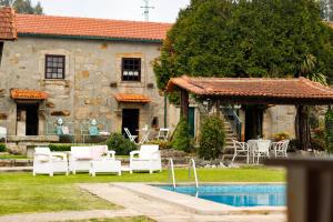 a house with chairs and a pool in front of it at Casa dos Laceiras in Sandim