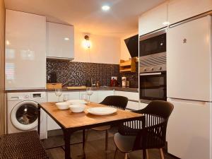 a kitchen with a wooden table with chairs and a washer at Dúplex tipo loft de estilo selvático y safari, con encanto y a pasos del mar in Valencia