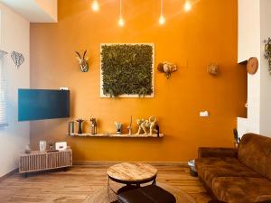 a living room with orange walls and a couch at Dúplex tipo loft de estilo selvático y safari, con encanto y a pasos del mar in Valencia