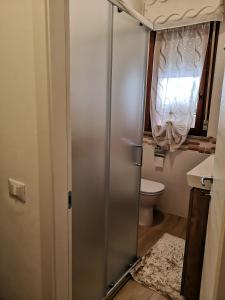 a bathroom with a shower with a toilet and a window at SummerJoy in Bibione