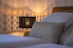 a lamp sitting on a bed next to some pillows at Bodrog Borműhely Vendégház in Bodrogkisfalud