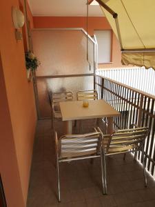 a table and chairs on a balcony with a staircase at SummerJoy in Bibione