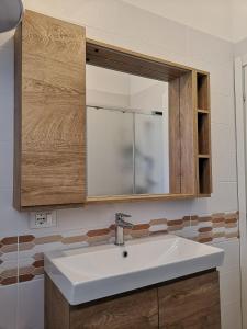 a bathroom with a white sink and a mirror at SummerJoy in Bibione +6 photos