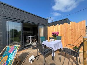 eine Terrasse mit Tisch und Stühlen und einem Zaun in der Unterkunft Les petites maisons dans la monterie - Le Jardin - in Saint Lo + 11 Fotos