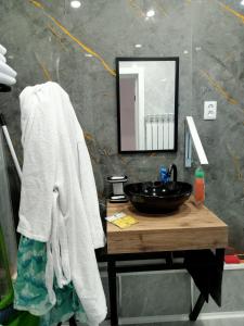 a bathroom with a sink and a mirror at Family Home in Petropavlovsk +4 photos