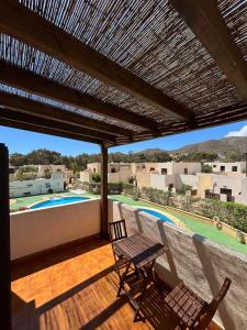 eine Terrasse mit Tisch und Stühlen und ein Swimmingpool in der Unterkunft Casa Eck San Jose in San José