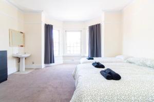 a bedroom with two beds with blue slippers on them at Brookvale Guest House Room 9 in Southampton