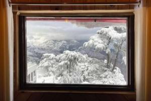 a window with a view of a snow covered mountain at RATAN HOMES Sunrise Valley in Jāmb +2 photos