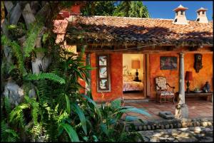 a house with a patio with a couch and a chair at Los Almendros de San Lorenzo in Suchitoto