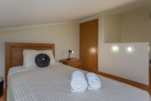 a bedroom with a bed with two towels on it at Glenridge Resort By Albufeira Rental in Albufeira