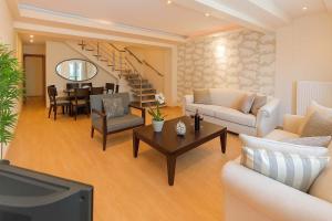 Una sala de estar con un sofá, un televisor y una mesa. en Hera's Resort with Private Pool and Lush Garden, en Sani Beach 24 fotos más