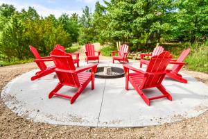 a group of red chairs sitting around a fire pit at The Lake House Inn in Laurie