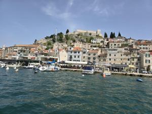 a group of boats in the water near a city at La Vie Seaside Residences in Šibenik