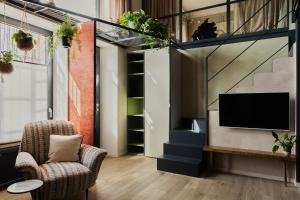 a living room with a chair and a tv at Bellevue Bocconi Suite in Milan