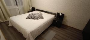 a bed with a black and white pillow on it at Kapteni kodu in Paldiski