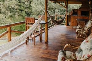 a hammock on the deck of a cabin at Cabana Refúgio Coqueiral in Rio Forcação
