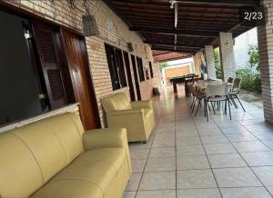 a living room with a couch and a table and chairs at La Belle de Jour in Paracuru