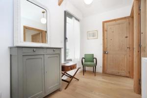 a bathroom with a mirror and a green chair at Bonne rencontre in Saint Malo