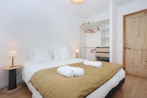 a bedroom with a large bed with towels on it at Bonne rencontre in Saint Malo