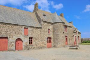 an old stone building with red doors and windows at Bonne rencontre in Saint Malo +30 photos
