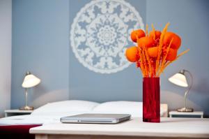 a red vase with orange flowers on a table at Cilantro Bed & Breakfast in Wrocław