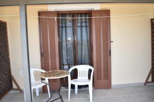 a table and chairs on the balcony of a house at Macrame House Zakynthos in Vasilikos