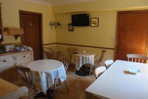 a kitchen with two tables and chairs and a tv at Woodville B&B in Bray