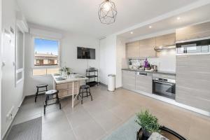 a large kitchen with a table and chairs in it at Le Canephora - 800m mer, terrasse, parking, 400m gare in Saint Malo