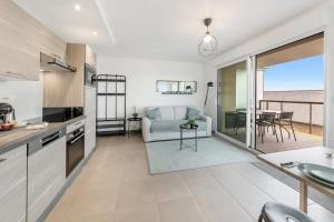 a kitchen and living room with a view of the ocean at Le Canephora - 800m mer, terrasse, parking, 400m gare in Saint Malo