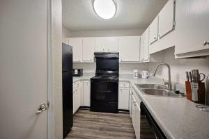 a kitchen with white cabinets and a black refrigerator at Northtown Apartments 12h I Comfy 2 Bed 2 Bath in Jackson +9 photos