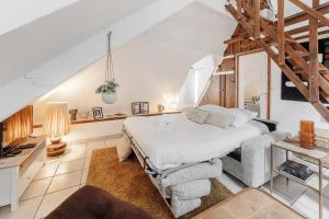 a bedroom with a white bed and a staircase at Le 38 - Studio atypique au coeur de Cancale-3 pers in Cancale