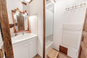 a white bathroom with a sink and a shower at Le 38 - Studio atypique au coeur de Cancale-3 pers in Cancale