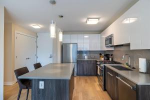 a kitchen with white cabinets and a counter top at Luxury Apt Near Downtown in Stamford