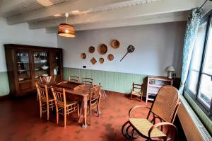 a dining room with a wooden table and chairs at Maison cosy & jardin privé Plages à 5 min in Tourville-sur-Sienne