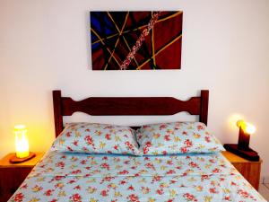1 dormitorio con 1 cama con una pintura en la pared en Sol de Geriba condominio com casas, en Búzios