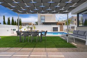 un patio con tavolo e sedie in una casa di Villa Violeta - 3bed Bungalow large pool a Protaras