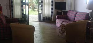 a living room with two couches and a television at Collina delle Rose in Bagnoregio