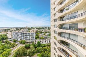 an apartment building with balconies and a city at Bellevue, appartement T2, terrasse & parking in Rennes
