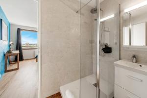 a bathroom with a glass shower and a sink at Bellevue, appartement T2, terrasse & parking in Rennes