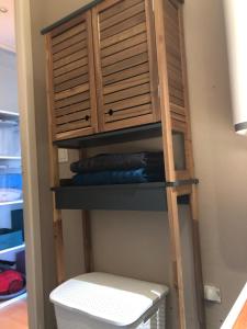 a wooden cabinet in a closet with a stool at Agréable studio in Combrit
