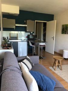 a living room with a couch and a kitchen at Agréable studio in Combrit