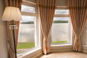 a room with two windows with a view of the water at Sapsan in Ternopilʼ