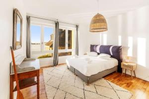 a bedroom with a bed and a large window at Albatros, grand duplex, 4 chambres, vue mer in Saint Malo