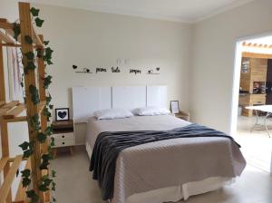 a bedroom with a bed in a white room at Casa aconchegante no interior in Boituva +21 photos