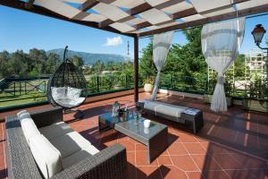 a patio with chairs and a table and a swing at VILLA DIONISIA in Dassia
